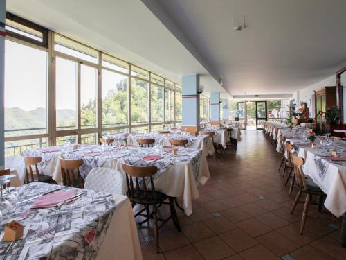 une salle de banquet avec tables et chaises et nappes blanches dans l'établissement Hotel Funivia, à Laveno-Mombello