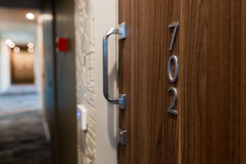 a wooden door with the number on it at Novotel Firenze Nord Aeroporto in Sesto Fiorentino