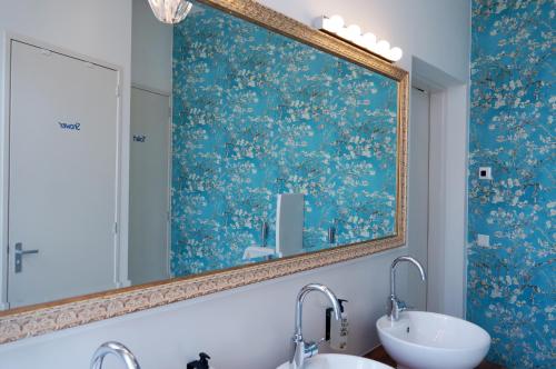 a bathroom with two sinks and a large mirror at De Bedstee Boutique Capsules in Amsterdam