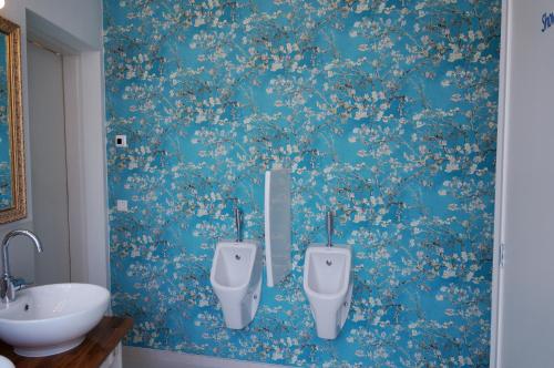 a bathroom with two urinals on a blue wall at De Bedstee Boutique Capsules in Amsterdam