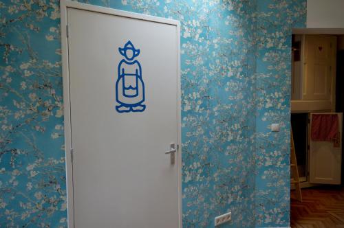a door in a room with blue floral wallpaper at De Bedstee Boutique Capsules in Amsterdam
