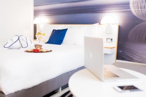 a bedroom with a bed with a laptop on it at Novotel Firenze Nord Aeroporto in Sesto Fiorentino