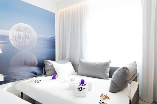 a room with a white bed with pillows at Novotel Firenze Nord Aeroporto in Sesto Fiorentino