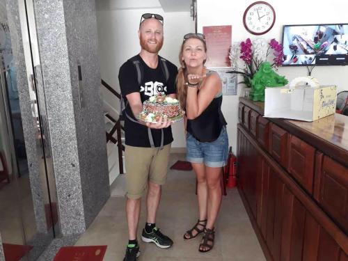 un hombre y una mujer sosteniendo un pastel en Nice Hotel, en Da Nang