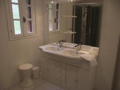 a white bathroom with a sink and a mirror at Villa Emmony in Santo-Pietro-di-Venaco