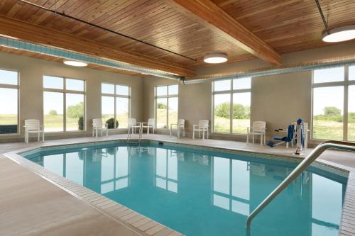 a pool with blue water in a building with windows at Country Inn & Suites by Radisson, Indianola, IA in Indianola