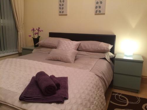 a bedroom with a bed with purple towels on it at Greencastle in Kilkeel