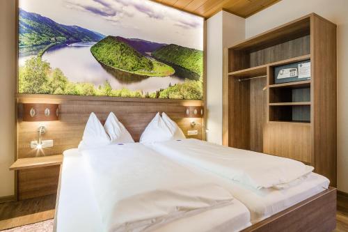 ein Schlafzimmer mit einem großen Bett und einem Gemälde an der Wand in der Unterkunft Gasthof Gierlinger in Obermühl