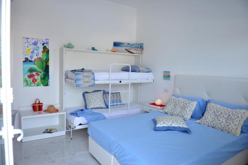 ein kleines Schlafzimmer mit einem blauen Bett und Regalen in der Unterkunft Bahiamar in Torre Lapillo