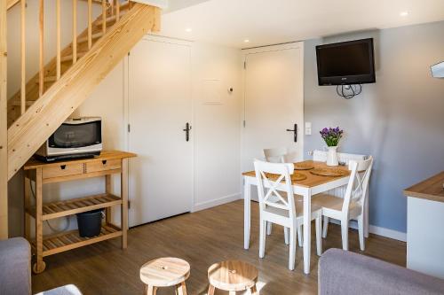 ein Wohnzimmer mit einem Esstisch und einer Treppe in der Unterkunft Slapen aan de Bosweg in Zoutelande