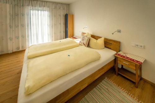 a bedroom with a large bed with a wooden headboard at Haus Mariandl in Nesselwängle