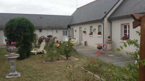 a house with a garden with flowers in the yard at Le Clos des Roses in Civray-de-Touraine