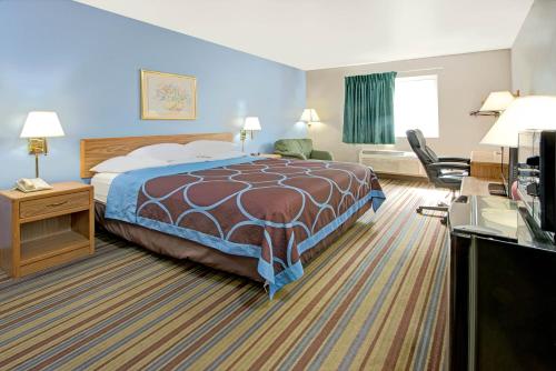 a hotel room with a bed and a desk at Super 8 by Wyndham Pontoon Beach IL/St. Louis MO Area in Pontoon Beach