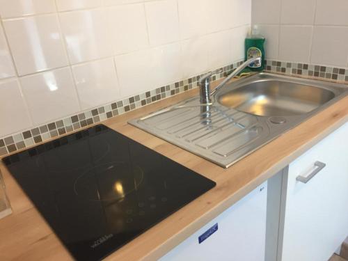 a kitchen counter with a sink and a stove at Lumineux T2 Vieille ville 3pers parking gratuit - by La Source d'OrFée in Boulogne-sur-Mer