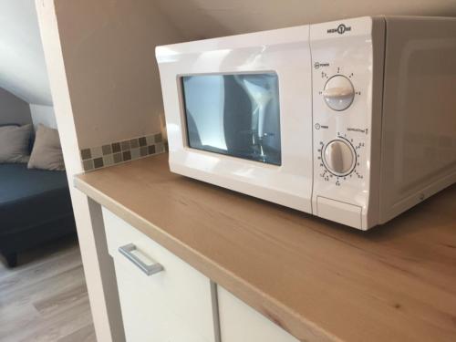 un four micro-ondes blanc assis au-dessus d'un comptoir dans l'établissement Lumineux T2 Vieille ville 3pers parking gratuit - by La Source d'OrFée, à Boulogne-sur-Mer