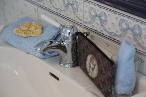 a bathroom sink with a towel and a faucet at B&B Chantery in Koksijde