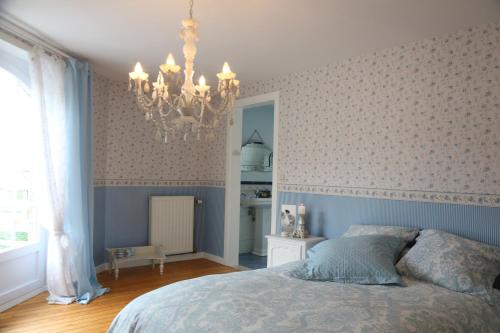 a bedroom with a bed and a chandelier at B&B Chantery in Koksijde