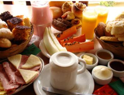 Pousada Sonho Verde في مونتي فيردي: طاولة مليئة بأطباق الطعام والمشروبات