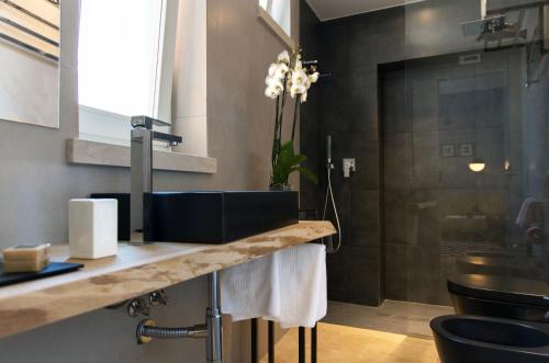 a bathroom with a counter with a sink and a shower at CinqueSuites Ortigia in Siracusa