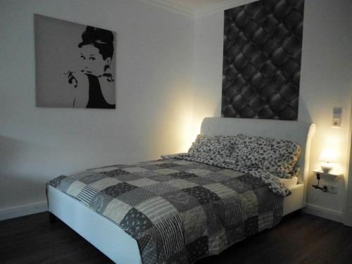 a bedroom with a bed and a picture on the wall at Apartment Regina in Möhnesee