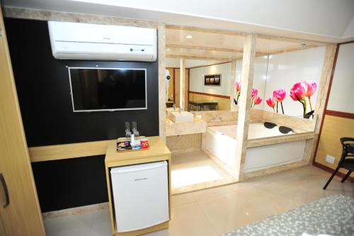 a room with a large bathroom with a large mirror at Hotel Premium Plaza in Muriaé