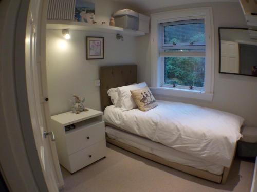 a small bedroom with a bed and a window at 16 Admiralty in Arrochar