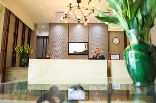 a man sitting at a reception desk in a lobby at Hotel Expo Abastos in Guadalajara