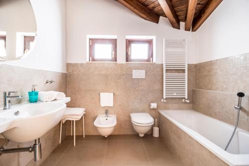 a bathroom with a tub and a toilet and a sink at Corte dei Nobili in Conversano