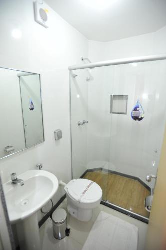 a bathroom with a shower and a toilet and a sink at Cllin Premium Plaza in Muriaé