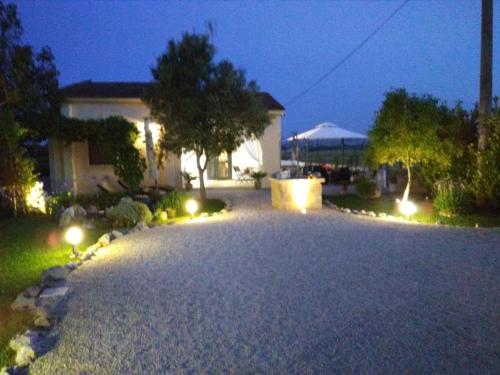 a driveway with lights in front of a house at night at Villetta Dote in Casarano