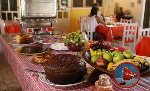 een tafel met taarten en fruit op een tafel bij Recanto do Barao Pousada in Jericoacoara