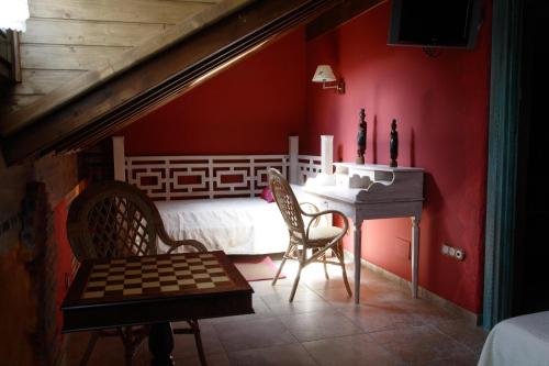 a bedroom with a bed and a table and chairs at Posada-Spa Privilegio de Vara in Noja