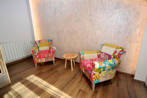 two chairs and a table in a room at Hotel Vall d´Aneu in Esterri d'Àneu