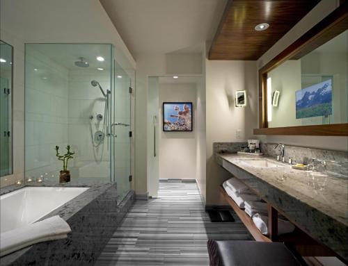 a bathroom with a sink, mirror, and bathtub at Fairmont Pacific Rim in Vancouver