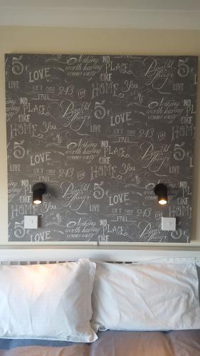 a wall covered in writing on a bedroom wall at Seabreeze in Littlestone-on-Sea