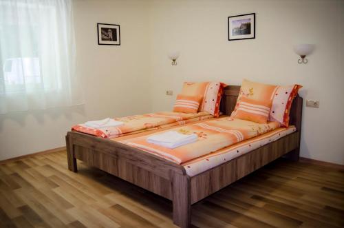 a couch with orange cushions sitting in a room at CSONGRÁDI VENDÉGVÁRÓ Apartmanok, Szarka ház in Csongrád