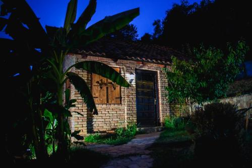 a brick house with a wooden door at night at Holiday Home Nektar Park in Bihać