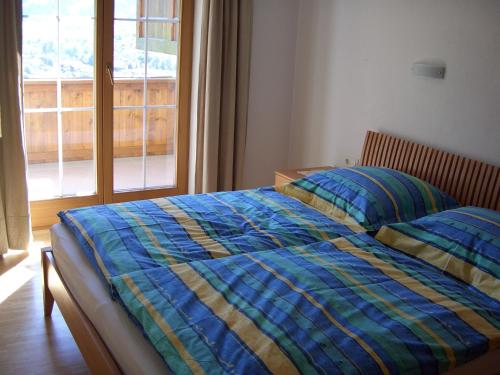 1 dormitorio con 2 camas y ventana en Ferienwohnung Sonnentraum, en Hainzenberg