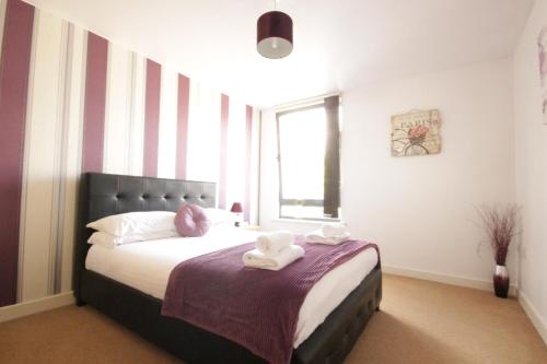 a bedroom with a bed with two towels on it at Marina Water View Apartment in Hull