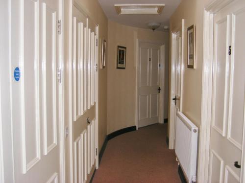 a hallway with white walls and white doors at The Kings Head Hotel in Abergavenny