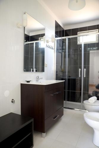 a bathroom with a sink and a shower and a toilet at Porto Smart Apartments- airport in Perafita