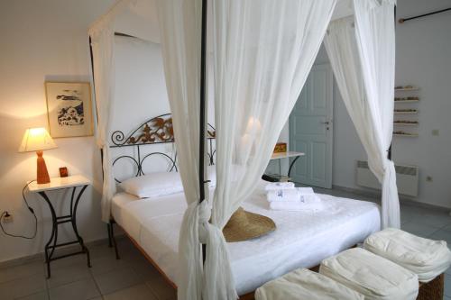 1 Schlafzimmer mit 2 Betten und weißen Vorhängen in der Unterkunft 360 Blue in Fira