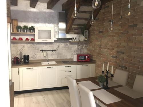 a kitchen with white cabinets and a brick wall at Ca del Pape in Venice