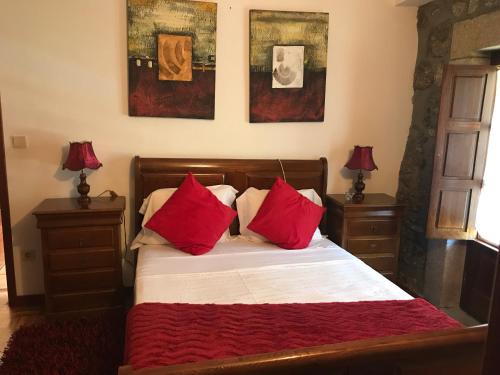 ヴィエイラ・ド・ミーニョにあるCasa do Serradorのベッドルーム1室(赤い枕のベッド1台付)