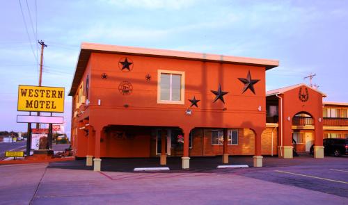 an orange building with stars on the side of it at Western Motel in Shamrock