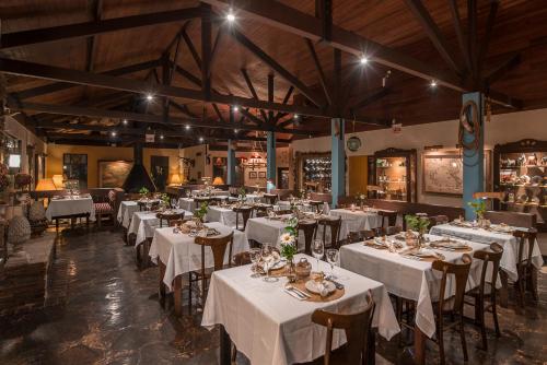 une salle à manger avec des tables et des chaises blanches dans l'établissement Rio do Rastro Eco Resort, à Bom Jardim da Serra