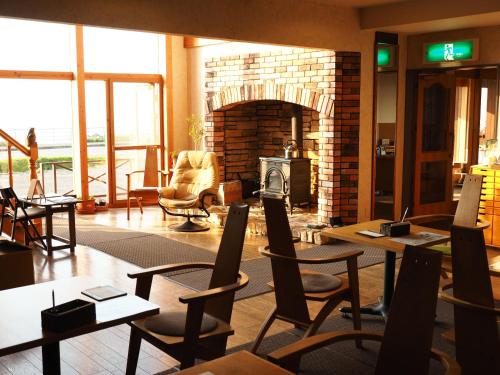 a living room with tables and chairs and a fireplace at Hotel Kifu Club Shiretoko in Shari