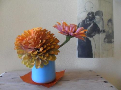 a blue vase with flowers in it on a table at B&B Casa Pascolone in Pegognaga