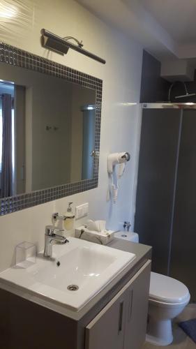 a bathroom with a sink and a toilet and a mirror at DOMKI w Zaciszu in Ruś