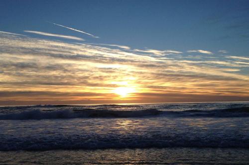 a sunset on the beach with the ocean at Sandcastles On Currumbin Beachfront, Gold Coast in Gold Coast